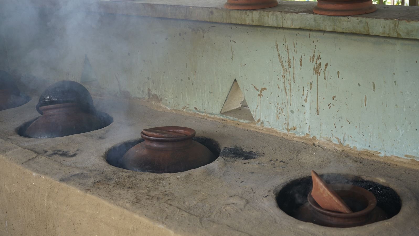 Clay kadhni pots slow-simmering milk on a traditional chulha